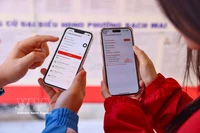 De jeunes électeurs consultent les profils des candidats sur l’application VNeID. Photo: VNA