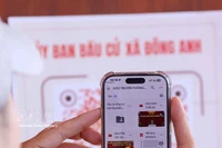 Les électeurs scannent un code QR à l’aide de leur smartphone afin de vérifier rapidement les informations relatives à leur droit de vote. Photo : VNA