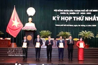 Trân Luu Quang (2e à partir de la droite), membre du Bureau politique et secrétaire du Comité du Parti de Hô Chi Minh-Ville, et Nguyên Duc Hai (3e à partir de la gauche), vice-président de l'Assemblée nationale, remettent les décisions de reconnaissance aux membres du Conseil populaire municipal. Photo: VNA