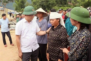 Le vice-Premier ministre Le Thanh Long et des sinistrés à Chieng So. Photo: VNA