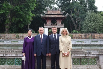 Le secrétaire général du Parti, Tô Lâm, et son épouse Ngo Phuong Ly, le président français, Emmanuel Macron, et son épouse Brigitte Macron, au Temple de la Littérature – Quoc Tu Giam. Photo: VNA