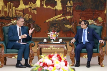 Le Premier ministre Pham Minh Chinh et l’ambassadeur de France au Vietnam, Olivier Brochet. Photo: VNA