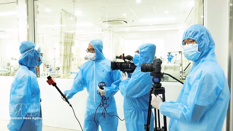 Des journalistes couvrant l’épidémie de Covid-19 à Da Nang. Photo: VNA