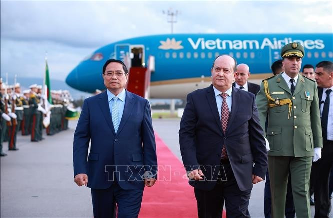 Le Premier ministre algérien Sifi Ghrieb accueille son homologue vietnamien Pham Minh Chinh (gauche) à l'aéroport international Houari-Boumediene. Photo: VNA