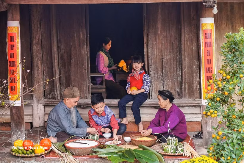 Les membres d'une même famille préparent ensemble des bánh chưng, les gâteaux traditionnels du Têt. Photo: VNA