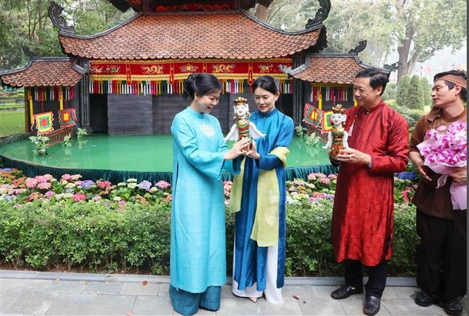 Mme Ngô Phuong Ly, épouse du secrétaire général To Lam, a offert une marionnette sur l'eau à Mme Loo Tze Lui, épouse du Premier ministre singapourien Lawrence Wong. Photo : VNA
