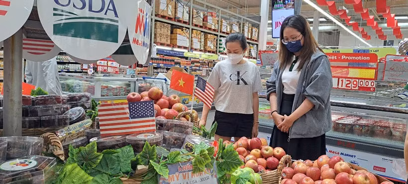 Des consommateurs choisissent des pommes américaines dans un supermarché à Hô Chi Minh-Ville. Photo : nld.com.vn