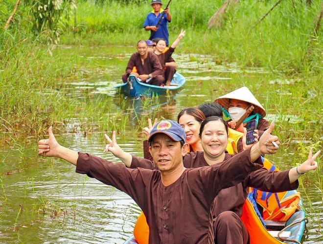 Les visiteurs apprécient les balades en pirogue à travers la forêt, au sein d’un site de tourisme écologique dans la région de la forêt d’U Minh Hạ. Photo: VNA