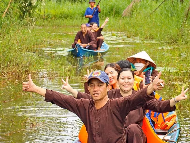Les visiteurs apprécient les balades en pirogue à travers la forêt, au sein d’un site de tourisme écologique dans la région de la forêt d’U Minh Hạ. Photo: VNA