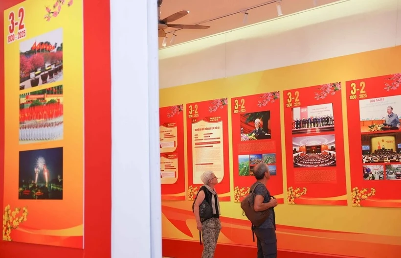 Des visiteurs internationaux visitent une exposition sur le Parti à Hanoi à l'occasion du 95e anniversaire de la fondation du Parti communiste du Vietnam. Photo: VNA