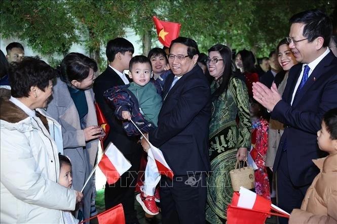 Le Premier ministre Pham Minh Chinh (centre) rencontre la communauté vietnamienne en Pologne. Photo: VNA