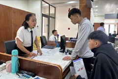 Le personnel du Centre de services administratifs publics du quartier de Tam Ky, dans la ville de Dà Nang, guide les gens dans les procédures administratives. Photo : VNA
