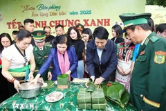 Le président Luong Cuong et la secrétaire du Comité du Parti de la province de Lai Châu, Giang Pao My, emballent des gâteaux carrés de riz gluant dans la commune de Pa Tân, district de Sin Hô, province de Lai Châu, le 9 janvier 2025. Photo : VNA