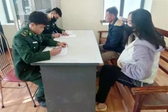 Và A Chứ (2e, à droite), arrêté pour organisation de l’immigration illégale, devant les enquêteurs. Photo : VNA