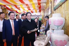 Le Premier ministre Pham Minh Chinh (à droite, au premier plan) visitant un stand d’exposition des produits artisanaux, à Hanoi, le 27 décembre. Photo: VNA