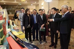 Les délégués visitent un stand d’exposition au Forum de promotion du commerce et de l’investissement Vietnam-Laos. Photo : VNA