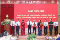 Le secrétaire général Tô Lâm remet au Comité du Parti du FPV et aux organisations de masse centrales la décision n°304-QD/TW du Politburo, à Hanoi, le 23 juin. Photo : VNA