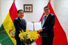 L’ambassadeur du Vietnam au Brésil concurremment en Bolivie, Bui Van Nghi (à gauche), remet à Miguel Ángel Pérez la décision du vice-Premier ministre et ministre des Affaires étrangères de le nommer au poste de consul honoraire du Vietnam en Bolivie. – VNA 