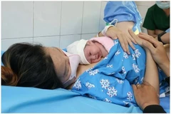 Une femme regarde son nouveau-né qui vient tout juste de naître. Photo: TNO