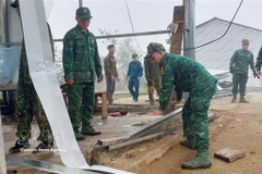 Des soldats aident des habitants de la commune de Pa Ủ (province de Lai Châu) à stabiliser leurs conditions de vie après une tempête de grêle et de forts vents survenus vers 18 heures le 17 mars. Photo: VNA
