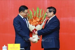 Le Premier ministre Pham Minh Chinh (à droite) félicite Lê Manh Hung pour sa nomination au poste de ministre par intérim de l’Industrie et du Commerce. Photo : VNA