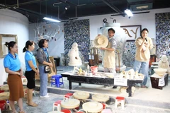 Des touristes dans le village de poterie de Bat Tràng. Photo: HNM