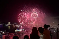 Des touristes regardent un feu d’artifice dans la ville de Dà Nang. Photo : VNA