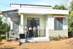 Y Dani Hdok, domicilé dans l’hameau de Kla, commune de Dray Sap, district de Krong Ana, et sa femme devant leur maison nouvellement construite. Photo: VNA
