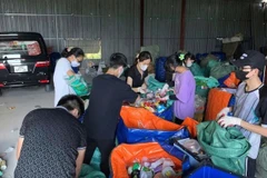 Des bénévoles du groupe Tagom, dans le quartier résidentiel de Thanh Xuân Bac, à Hanoi, trient les matières recyclables comme des bouteilles et des sacs en plastique des déchets ménagers. Photo : Tagom