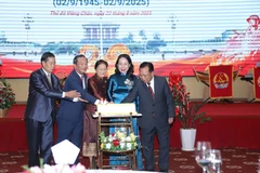 La vice-présidente vietnamienne Vo Thi Anh Xuân et la vice-présidente lao Pany Yathotou ainsi que les délégués découpent un gâteau d'anniversaire lors de l’événement. Photo : VNA
