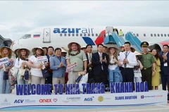 Des touristes russes prennent une photo souvenir avec des délégués représentant la province de Khanh Hoa. Photo : VNA