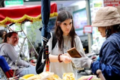Des touristes étrangères explorent la cuisine de rue dans le Vieux quartier de Hanoi. Photo : VNA