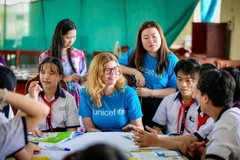 Des membres du personnel de l’UNICEF participent à une discussion avec des enfants vietnamiens. Le partenariat de 50 ans entre le gouvernement vietnamien et l’UNICEF a connu une transformation significative. Photo : UNICEF Vietnam