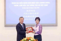 La directrice générale de l’Agence vietnamienne d’information (VNA), Vu Viêt Trang, offre un cadeau de souvenir au rédacteur en chef du Quotidien du Peuple de la Chine, Chen Jianwen. Photo: VNA