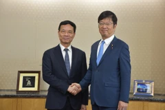 Le ministre d’État japonais des Affaires intérieures et des Communications, Adachi Masashi (à droite) et le ministre des Sciences et des Technologies, Nguyên Manh Hung, se serrent la main, à Tokyo, le 2 octobre. Photo : VNA