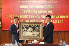 Le président Luong Cuong offre un tableau de Khue Van Cac (Pavillon de la Constellation des Lettres), faisant partie du temple de la Littérature, à l’ambassade du Vietnam au Laos. Photo : VNA