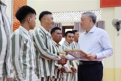 Le vice-Premier ministre permanent Nguyên Hoa Binh remet les certificats d’amnistie aux personnes graciées. Photo: VNA