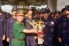 Le colonel Nguyên Dinh Chuân, commissaire politique du commandement militaire de la province de Binh Duong, offre des fleurs en guise de remerciement à la délégation cambodgienne. Photo: VNA