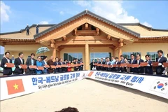 Les délégués sud-coréens et vietnamiens signent des tuiles à contruire le toit de la Maison communautaire de Bonghwa. Photo : VNA