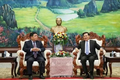 Le secrétaire général et président lao Thongloun Sisoulith et le vice-Premier ministre vietnamien Nguyên Chi Dung (à gauche), lors de leur rencontre à Vientiane, le 9 juillet Photo : VNA