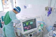Un agent de santé pratique des soins à un patient atteint de Covid-19. Photo : laodong.vn