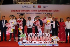 Le comité d'organisation a offert des fleurs pour féliciter les premiers passagers arrivés à Dà Nang par un vol d'Emirates. Photo : VNA