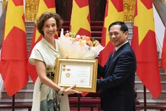 Le vice-Premier ministre et ministre des Affaires étrangères Bui Thanh Son remet à la directrice générale de l’UNESCO, Audrey Azoulay, l’insigne « Pour la cause de la diplomatie vietnamienne». Photo : VNA