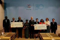 Le ministre conseiller Pham Quang Huy (à droite) pose avec les organisateurs du concours des champions des petites entreprises 2025. Photo : VNA