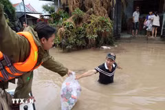 Des agents de la sécurité publique de la province de Dak Lak distribuent des vivres aux habitants des zones fortement inondées le long de la rivière Banh Lai. Photo : VNA