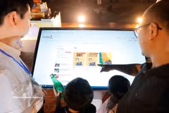 Des visiteurs découvrent l'application de livre électronique. Photo: VNA