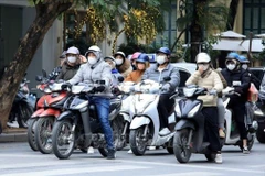 Des gens se déplacent par une journée froide à Hanoi. Photo : VNA