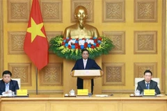 Le Premier ministre Pham Minh Chinh (debout) souhaite que les entreprises chinoises tirent parti du Vietnam comme pôle de production. Photo : VNA