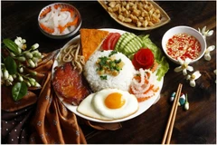 Le Com Tam est généralement servi avec une variété de viandes grillées, comme de savoureuses côtelettes de porc ou de la peau de porc effilochée. Les œufs au plat ou les omelettes apportent de la richesse, tandis que des légumes frais comme le concombre et des légumes marinés apportent un délicieux croquant. Source: izitour.com