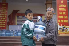 Dans la province de Thai Nguyên, dévastée par le typhon, une femme et son petit-enfant rapportent chez eux une bouteille d'eau potable fournie grâce au soutien de l'UE et de l'UNICEF. Photo : UNICEF Vietnam